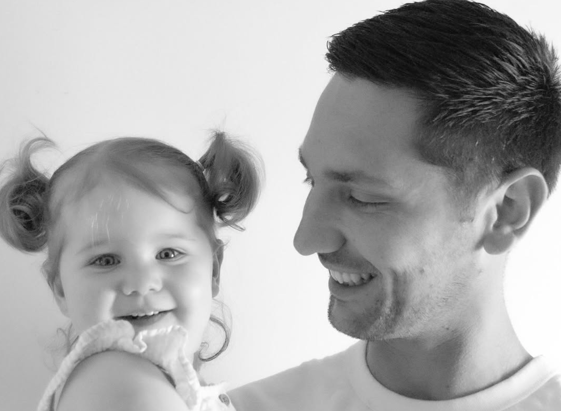 Father smiling at his young daughter, black and white portrait