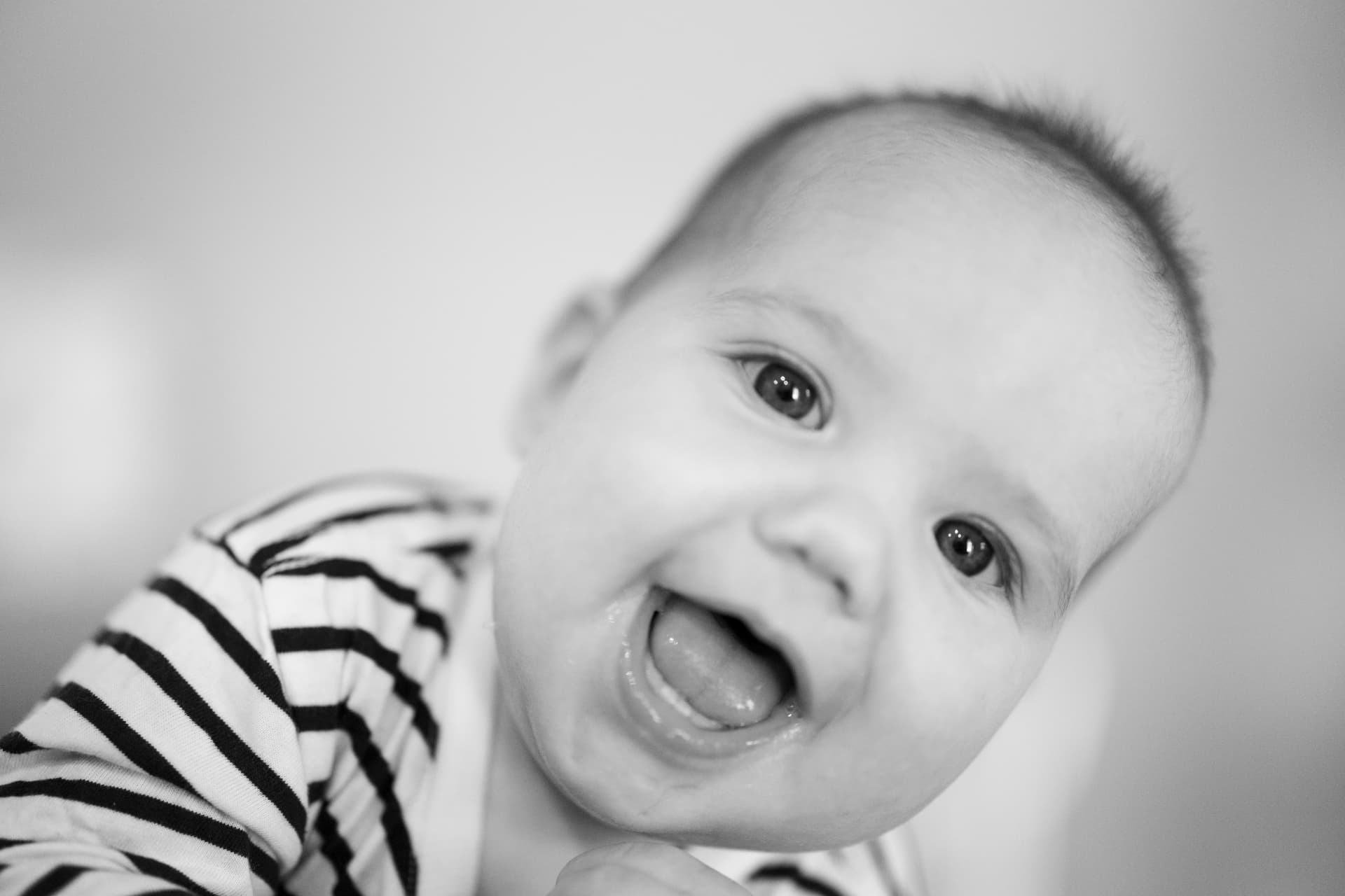 Close up black and white portrait of a smiling baby