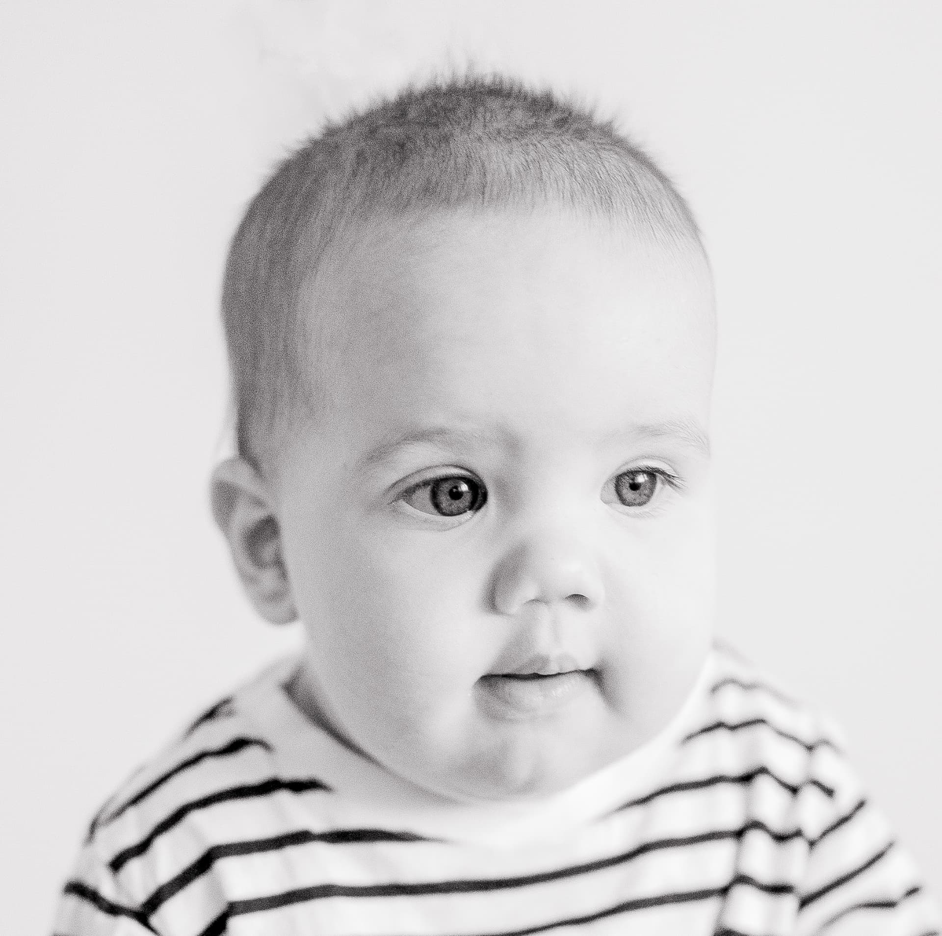 Black and white portrait of a young child in a striped top